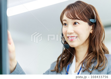 ヘッドセットを着けて電話を受ける女性 ヘッドセットを着けて電話を受ける女性 108433756