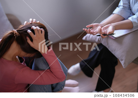 Asian psychologist women explaining about examining healthcare results and psychological health therapy to patient in home while female patient stressed and headache with anxiety in mental health 108434506