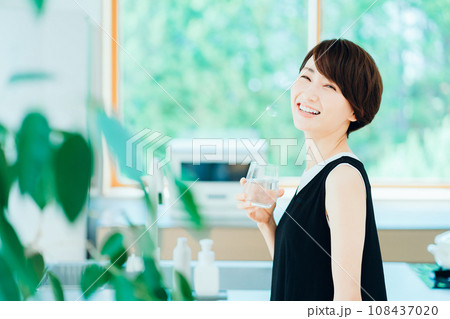 キッチンでお水を飲むミドル女性。 キッチンでお水を飲むミドル女性。 108437020
