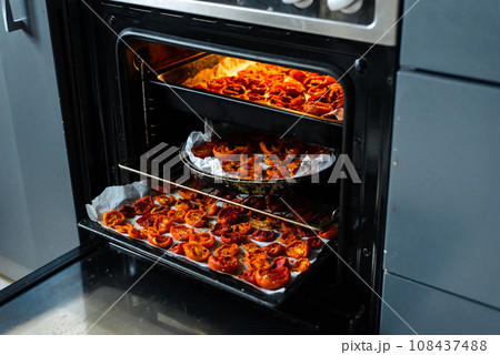 Cooking sun-dried tomatoes in the oven in the kitchen 108437488