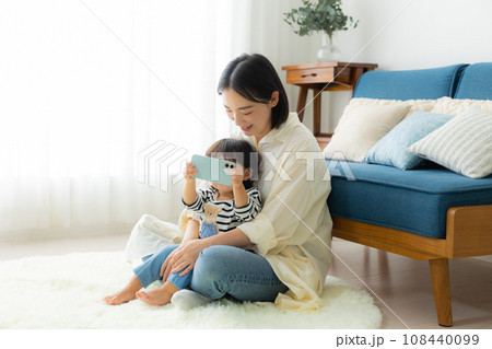 スマホを使うママと赤ちゃん スマホを使うママと赤ちゃん 108440099