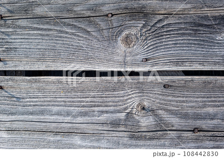 Elements of the walls of a wooden old village house. Wooden Log cabin walls texture. Weathered surface of an old wooden log house close-up. Old wooden log building in winter close-up. Elements of the walls of a wooden old village house. Wooden Log cabin walls texture. Weathered surface of an old wooden log house close-up. Old wooden log building in winter close-up. 108442830