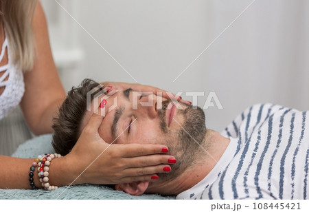 The woman healer performing method access or conciousness bars, alternative medicine concept, pseudoscientific method of alternative medicine that focuses on massaging various points on the head 108445421