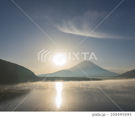 夜明けの富士山と水煙の湖 108445695