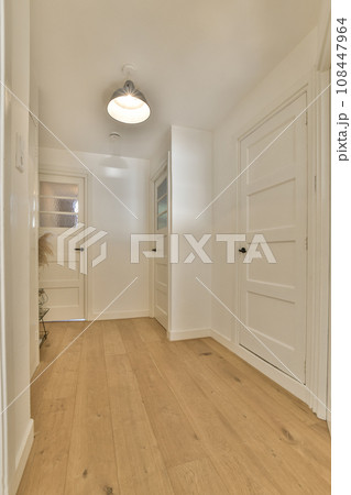 an empty room with white walls and wood flooring on the left side of the room, there is a door to the right an empty room with white walls and wood flooring on the left side of the room, there is a door to the right 108447964
