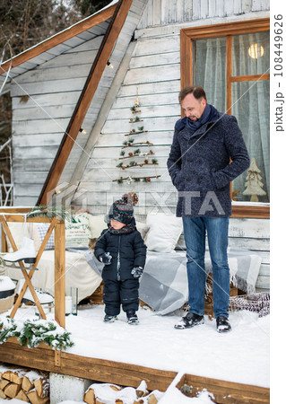 Little son having fun with dad while playing in winter park during New year and Christmas holidays 108449626