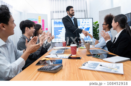 Diverse coworkers celebrate success with handshake. Concord Diverse coworkers celebrate success with handshake. Concord 108452918