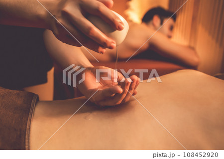 Masseuse prepare oil massage procedure for couple customer at spa. Quiescent Masseuse prepare oil massage procedure for couple customer at spa. Quiescent 108452920