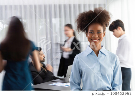 Young African businesswoman poses confidently in busy meeting room. Concord 108452965