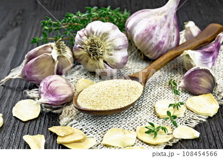 Garlic ground in spoon on wooden board 108454566