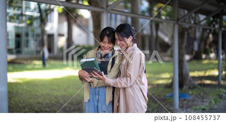 Happy young student chat with each other after class. Guy and girls wear casual clothes to study. Lifestyle College and University life concept, sincere emotions 108455737