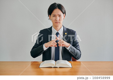 バツのポーズをする男性弁護士 108458999
