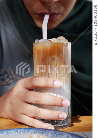 women drinking iced late in a transparent glass women drinking iced late in a transparent glass 108460360