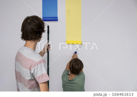 children paint the wall with a roller. teenagers spend time together helping to make repairs. children paint the wall with a roller. teenagers spend time together helping to make repairs. 108461613