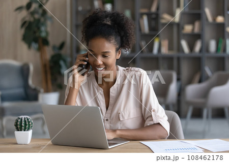 Happy young Black remote employee, worker talking on mobile phone 108462178