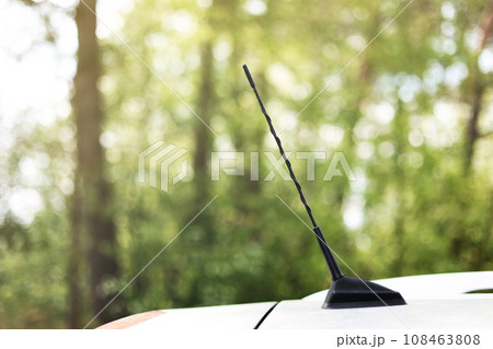green forest behind car antenna.Car antenna for receive the radio waves on roof car. Selective focus and close up 108463808