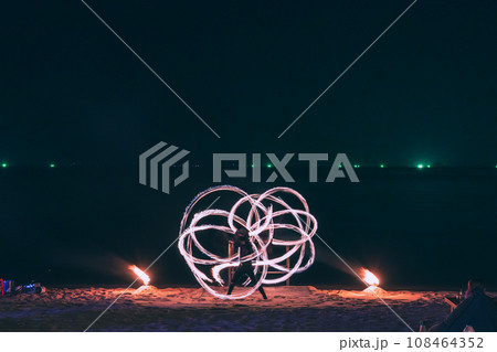 Fire steel wool with water reflection on sea in beach club party at night Samui Thailand 108464352