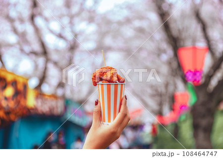 Karaage fried chicken food on asian woman hand in Japan sakura blossom festival Japanese street food concept Karaage fried chicken food on asian woman hand in Japan sakura blossom festival Japanese street food concept 108464747