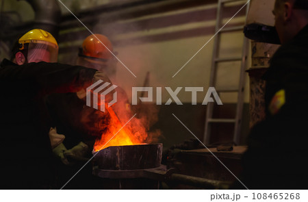 Pouring molten metal into a centrifugal machine in the foundry shop of metallurgical plant 108465268