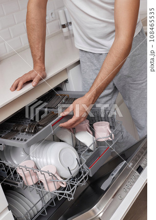 close-up, man unloading dishwasher machine in the kitchen 108465535