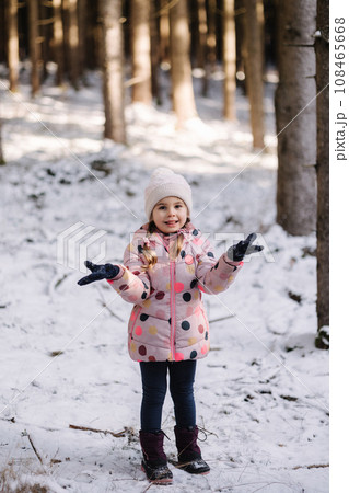 Adorable little girl in big snowy forest. Happy childhood 108465668