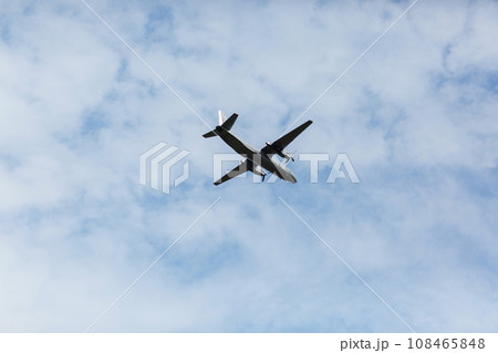 A beautiful view of a flying passenger wide-body airliner, an airplane, against a background of white clouds in a blue summer sky. selective focus 108465848