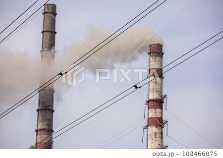 Smoke from two industrial chimneys, pipes, against the sky. Global warming. Air pollution. Ecological pollution. Air emissions polluting the city. Industrial waste is hazardous to health. Smoke from two industrial chimneys, pipes, against the sky. Global warming. Air pollution. Ecological pollution. Air emissions polluting the city. Industrial waste is hazardous to health. 108466075