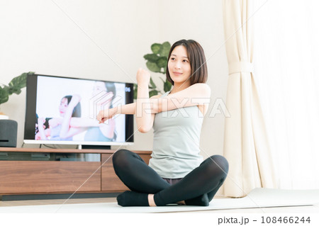 リビングでストレッチする若い女性 リビングでストレッチする若い女性 108466244