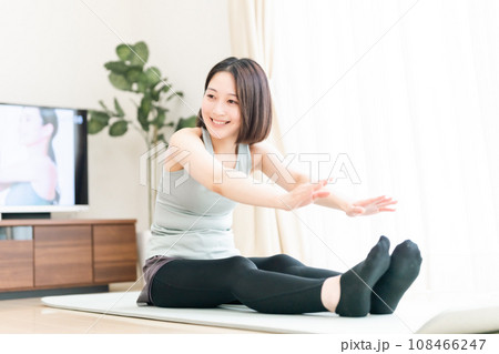 リビングでストレッチする若い女性 リビングでストレッチする若い女性 108466247