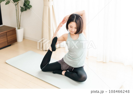 リビングでストレッチする若い女性 リビングでストレッチする若い女性 108466248