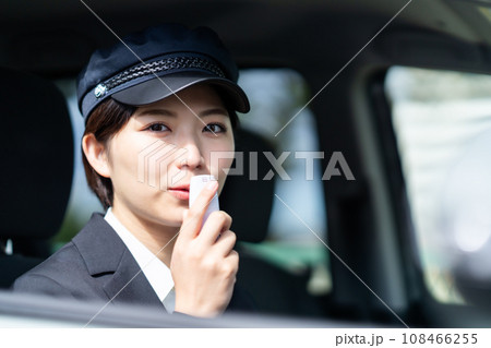 運転前にアルコールチェックをする若い女性ドライバー　 108466255