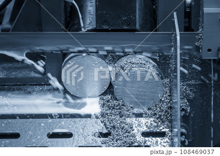 Close up scene the operation of band saw cutting machine cutting the metal shaft parts with coolant method. Close up scene the operation of band saw cutting machine cutting the metal shaft parts with coolant method. 108469037