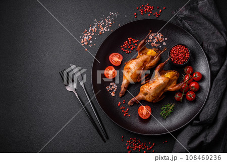 Roasted quail, partridge or pigeon stuffed with orange with spices and herbs 108469236