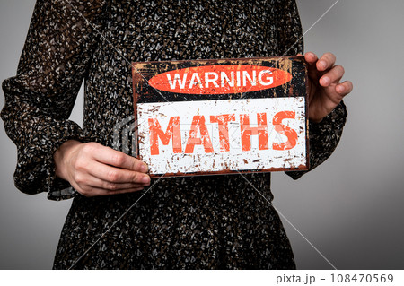 MATHS. Warning sign with text in the hands of a woman 108470569
