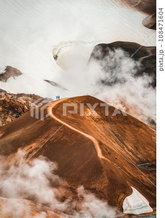 Landscape of Kerlingarfjoll volcanic mountain range with sulfur smoke and tourist hiking in summer at Icelandic Highlands 108471604