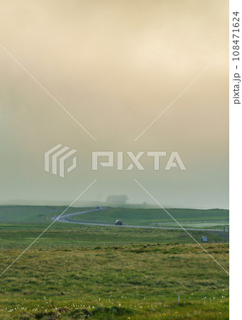 Car driving on curved asphalt road among the meadow in foggy day Car driving on curved asphalt road among the meadow in foggy day 108471624