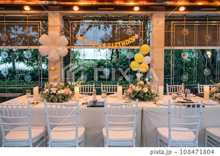 Setting up a banquet dining table for a birthday celebration, decor in restaurant Setting up a banquet dining table for a birthday celebration, decor in restaurant 108471804