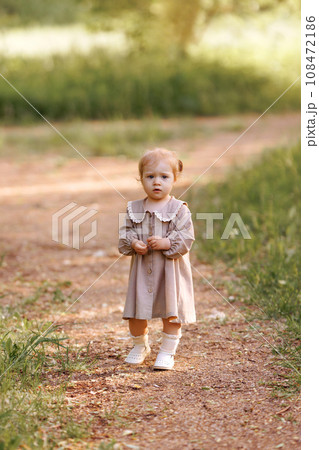 Small child girl walking in the park. 108472186