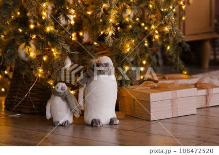 Cute penguin toys under the Christmas tree with lights Cute penguin toys under the Christmas tree with lights 108472520