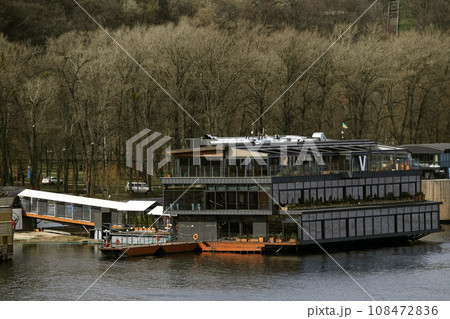 Kiev, Ukraine March 13, 2020: Restaurants floating on the water moored to the shore. Kiev, Ukraine March 13, 2020: Restaurants floating on the water moored to the shore. 108472836