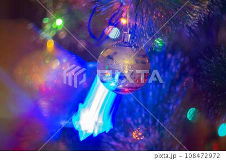Christmas decorations and colored lights garlands on Christmas tree. Bright lights and highlights against background of Christmas decorations. Christmas decorations and colored lights garlands on Christmas tree. Bright lights and highlights against background of Christmas decorations. 108472972