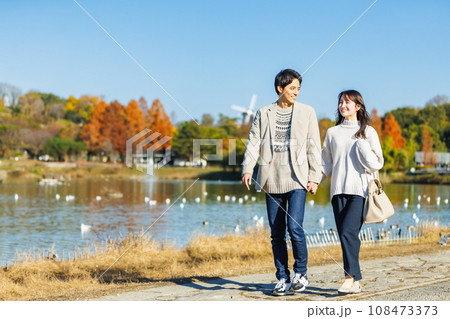 仲良く水辺を歩く若い男女 仲良く水辺を歩く若い男女 108473373