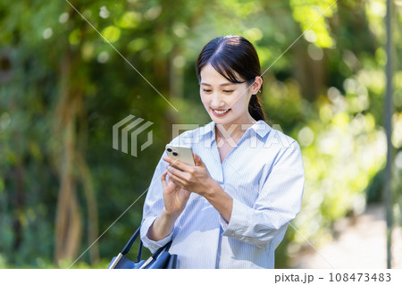 緑の中を歩く若い女性 108473483