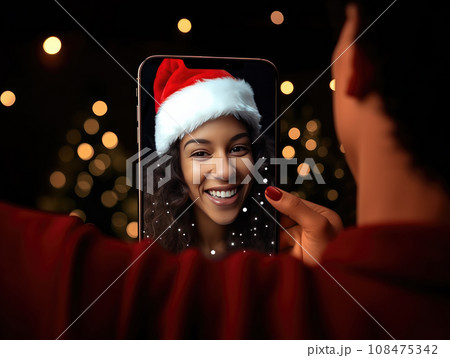 AI generation. African American woman wearing Santa hat during a Christmas video call on a smartphone with her friend. christmas, holiday and communication technology. AI generation. African American woman wearing Santa hat during a Christmas video call on a smartphone with her friend. christmas, holiday and communication technology. 108475342