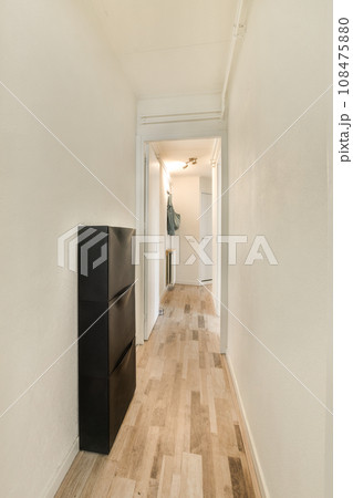 a long hallway with wood flooring and white walls in the room is very clean, but it's hard to see how a long hallway with wood flooring and white walls in the room is very clean, but it's hard to see how 108475880