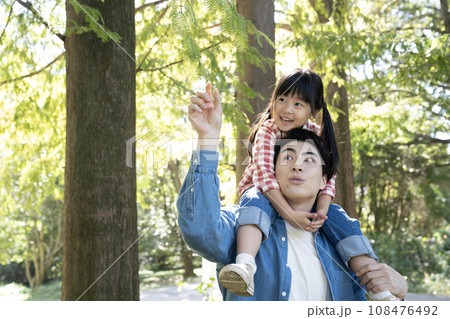 公園で肩車をして笑う親子 公園で肩車をして笑う親子 108476492