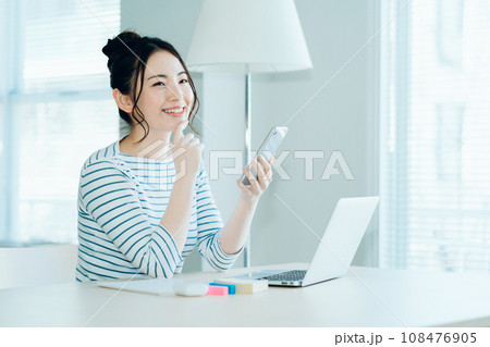 リビングでテレワークをする若い女性。 108476905