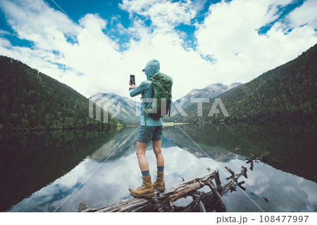 Woman walking on a one plank bridge in high altitude mountains 108477997
