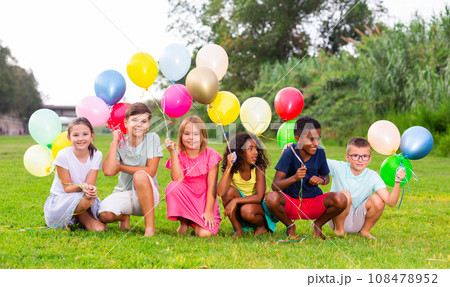 Barefoot kids playing with balloons on grass 108478952