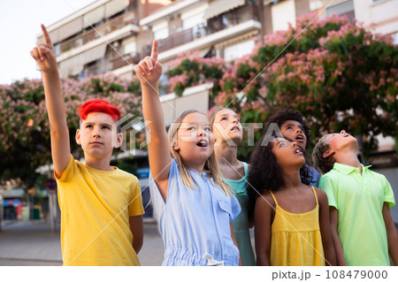 Curious preteen children pointing at something while walking outdoors 108479000